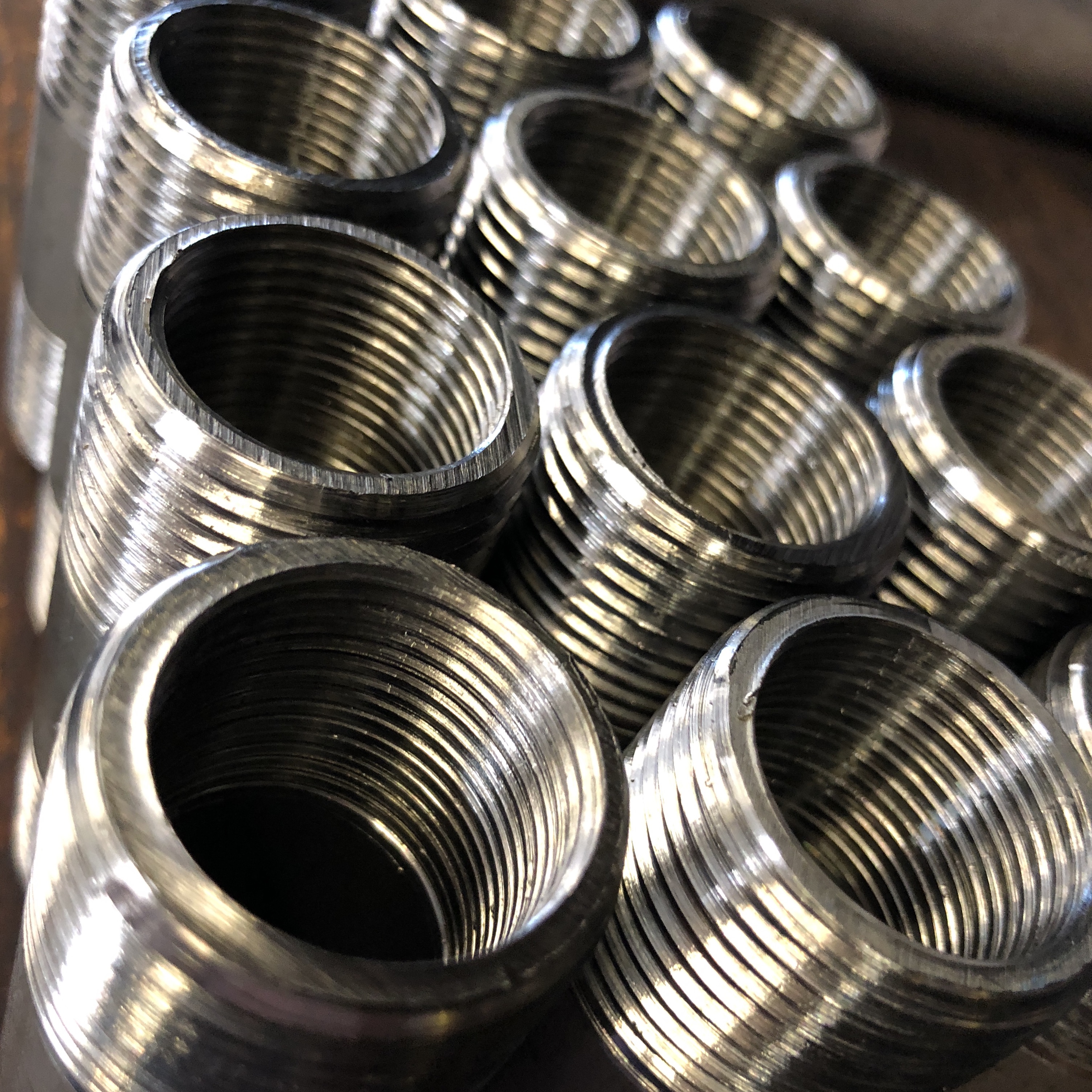 Close-up of stainless steel close nipples showing precision machined NPT threads