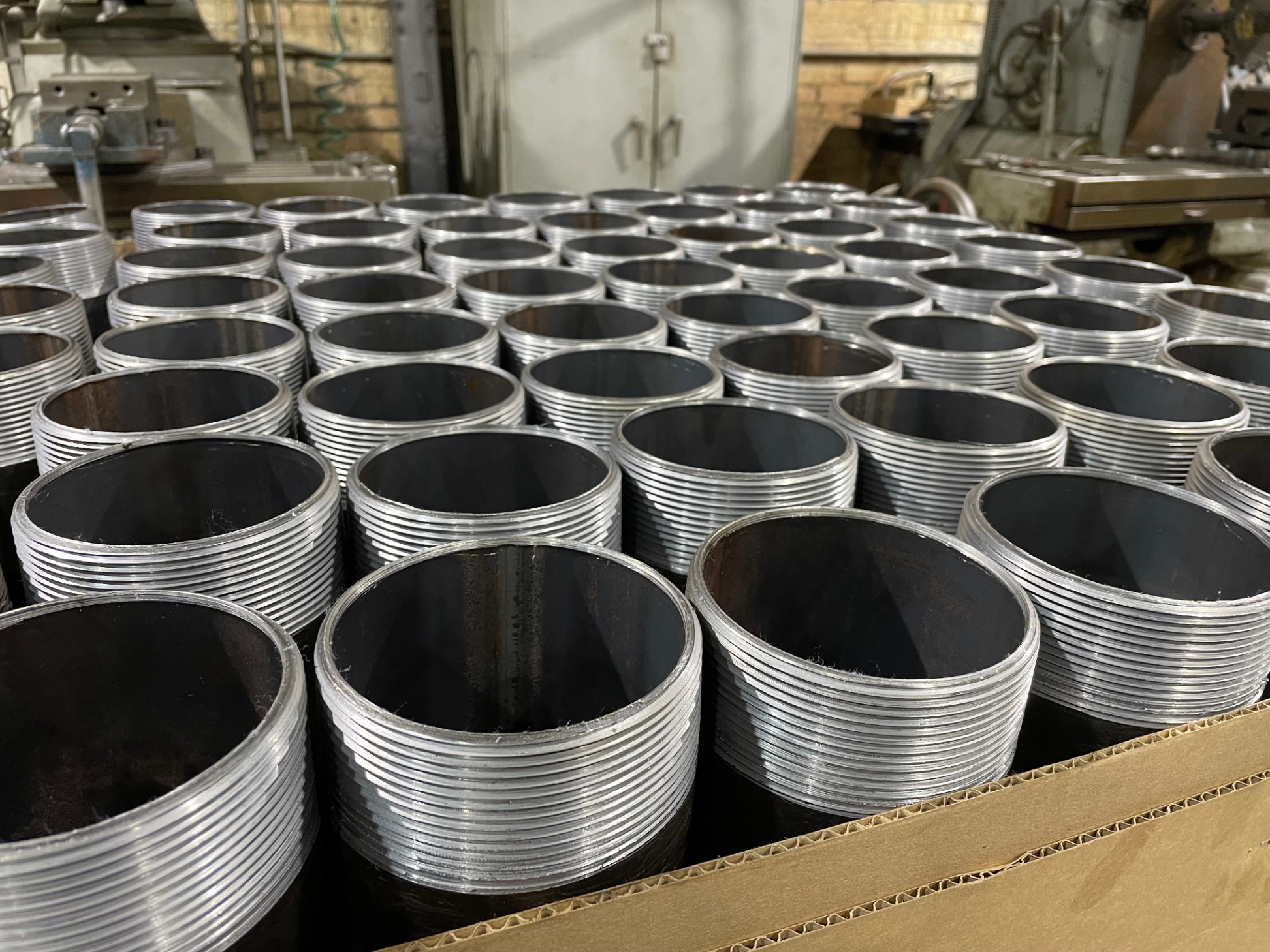 Large steel pipe nipples packed in a box at the E.A. Gray manufacturing facility